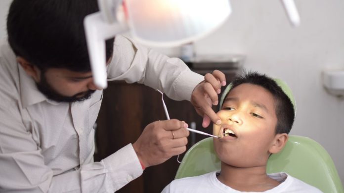 दातों का चेकअप करते हुए डॉक्टर